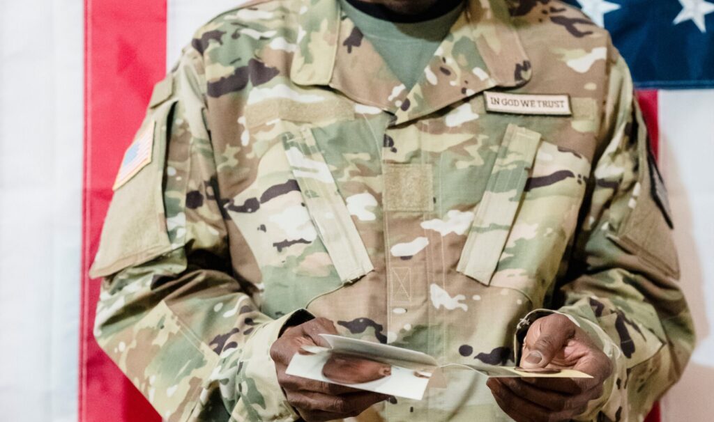 Veteran opening a letter in front of an American flag