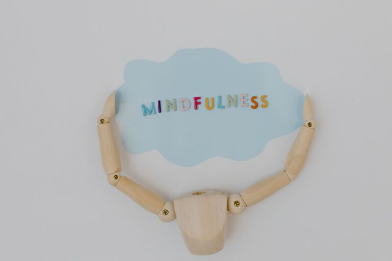 Mindfulness in colorful letters in a cloud with wooden arms and body holding onto it